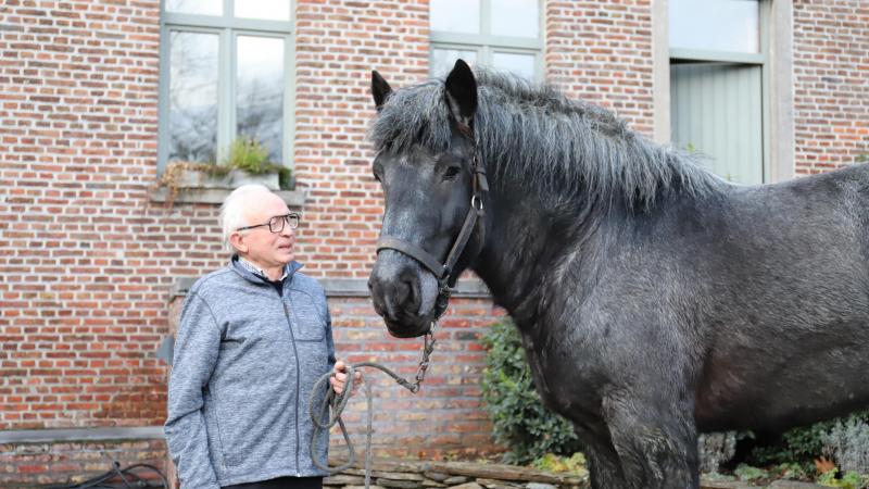 Cyr met zijn hengst Uniek van de Zaaidijk op de binnenkoer van de hoeve te Maarkedal in december 2022.