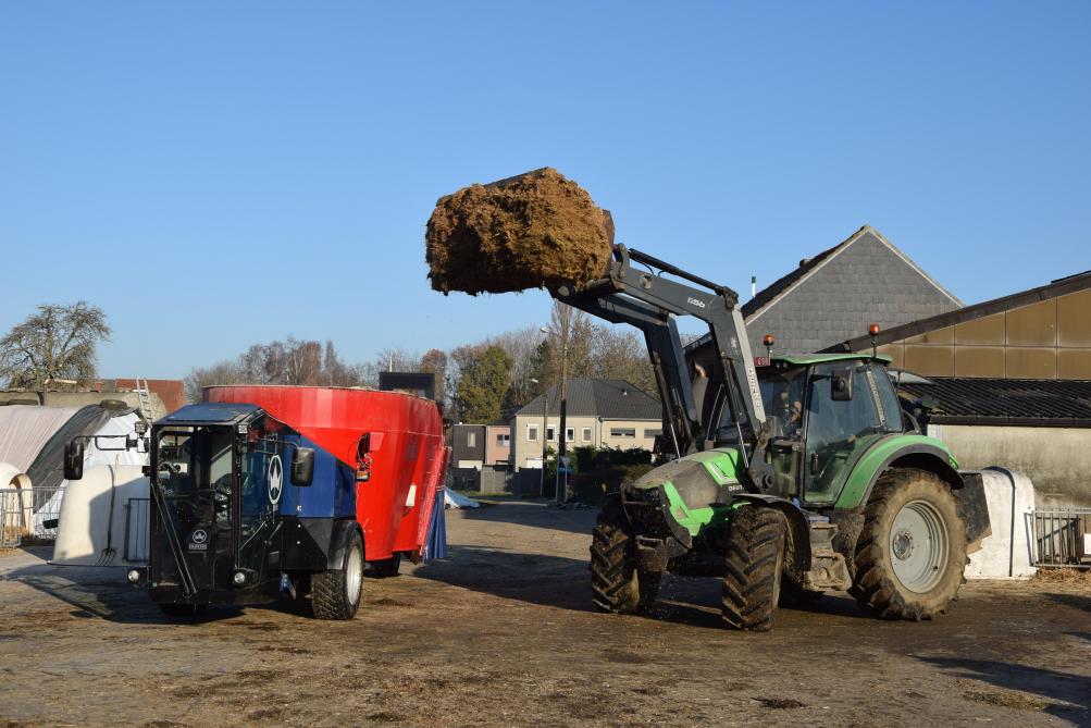 Een tractor met frontlader laadt de voermengwagen. Handig is dan dat deze een lage bouwhoogte heeft.