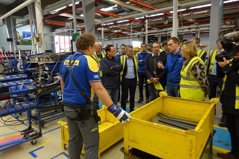 Minister Crevits kreeg een demonstratie van een exoskelet, een speciaal pak dat het tillen van zware voorwerpen lichter maakt en blessures voorkomt.