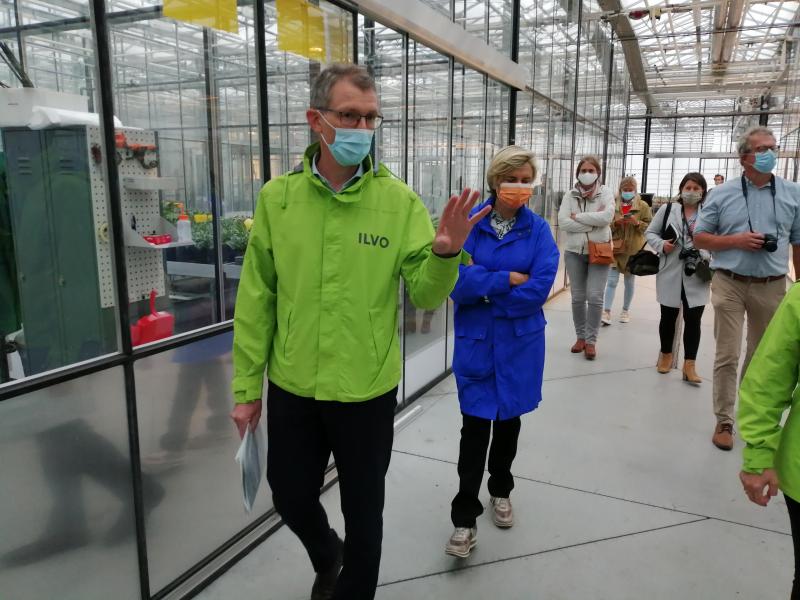 ILVO-topman Joris Relaes leidt Vlaams landbouwminister Hilde Crevits uit in een nieuw serrecomplex op ILVO.