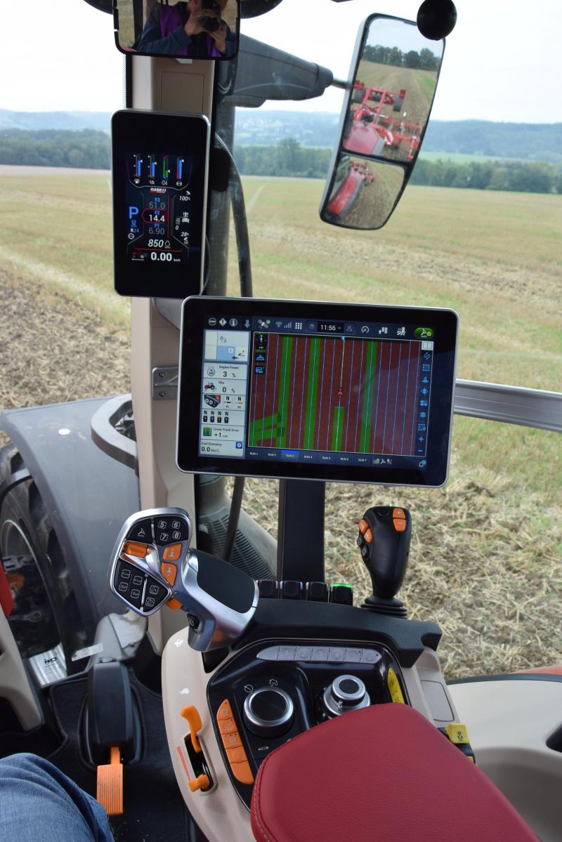 Zicht van boven naar onder op: tabletachtig display voor motor en transmissiefuncties, AFS Pro 1200-monitor, multifunctionele joystick en rechter armleuning.