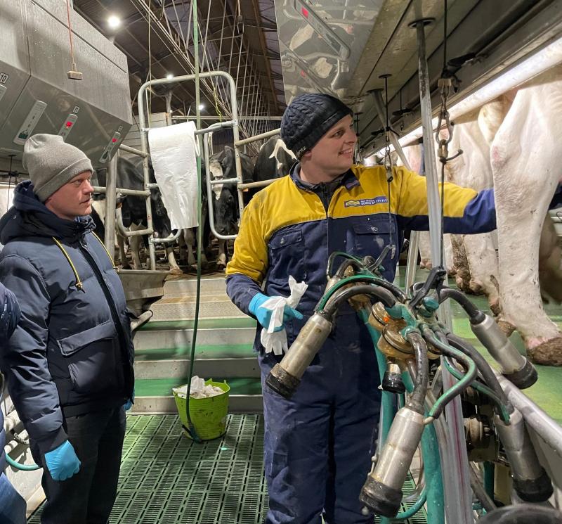 Nick luistert aandachtig als één van de melkveehouders het melkproces uitlegt.