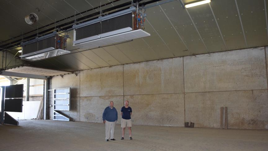 Jan en Josse Peeters in hun bewaarloods met bovenaan twee van de vier  mechanische koelelementen.