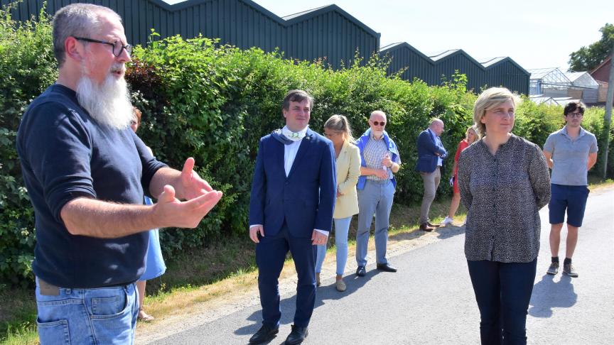 Landbouwminister Hilde Crevits en Kris Declercq, burgemeester van Roeselare, luisteren naar de uitleg van Luc Maertens, directeur van biohoeve De Lochting.