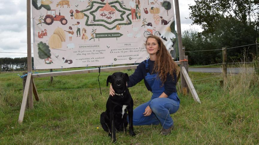 Janne met trouwe hond Storm voor het welkomstpaneel aan de ingang van de maïsdoolhof.
