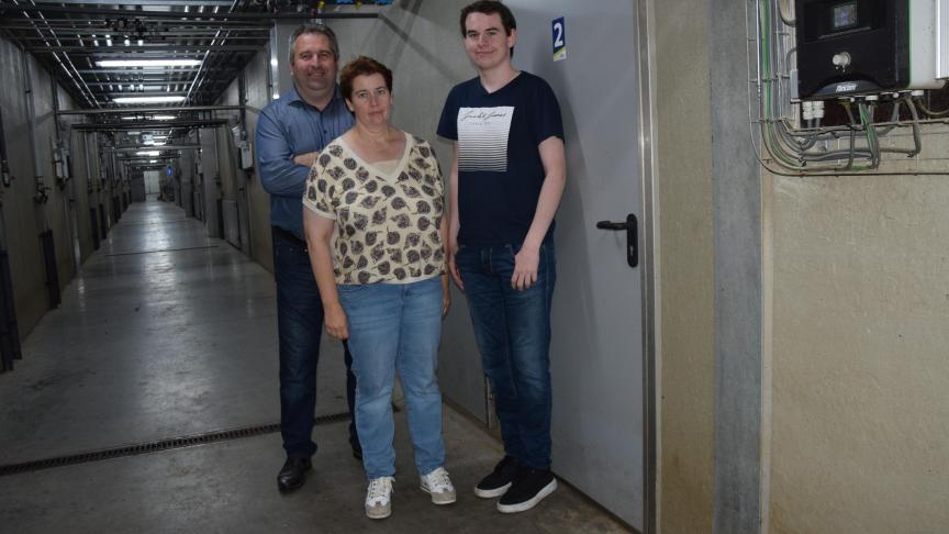 Frederik, Heidi en hun zoon René in de gang van de biggenstal.