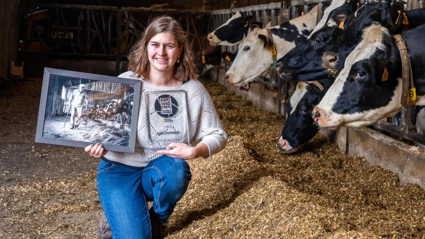 Ilse Louwagie met de winnende foto inde stal waar ze deze foto nam.